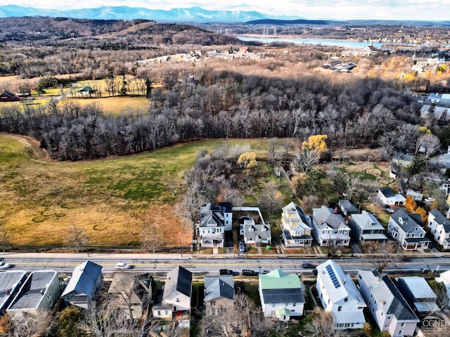 aerial perspective of suburban area featuring a mountainous background and a tree filled landscape
