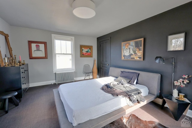 bedroom with radiator, dark colored carpet, and baseboards