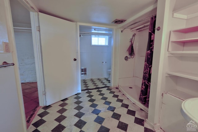 bathroom with tile patterned floors, a stall shower, and toilet