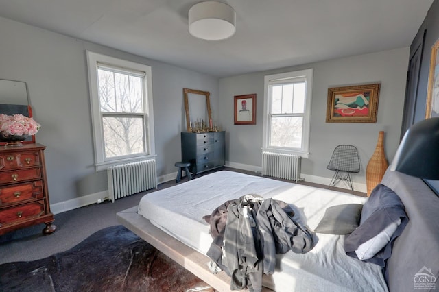 bedroom featuring radiator heating unit, baseboards, and carpet flooring