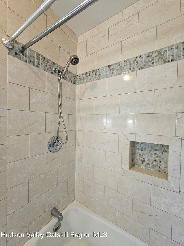 bathroom with tiled shower / bath combo