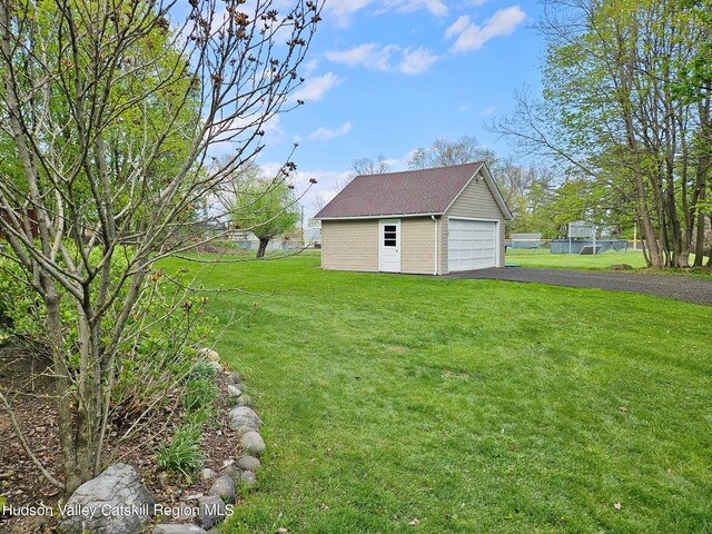 view of yard with a garage and an outbuilding