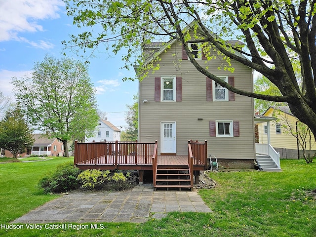 back of property featuring a lawn, a patio, and a deck