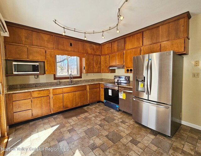 kitchen featuring rail lighting, stainless steel appliances, and sink