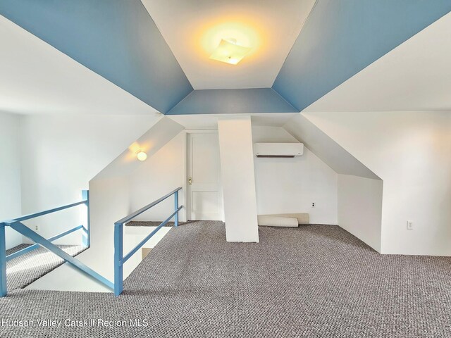 additional living space with carpet, vaulted ceiling, and a wall mounted AC