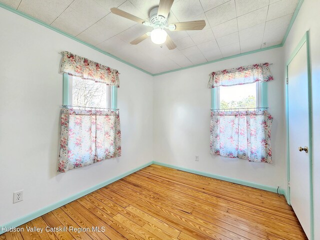 unfurnished room featuring light wood-type flooring, crown molding, ceiling fan, and a healthy amount of sunlight