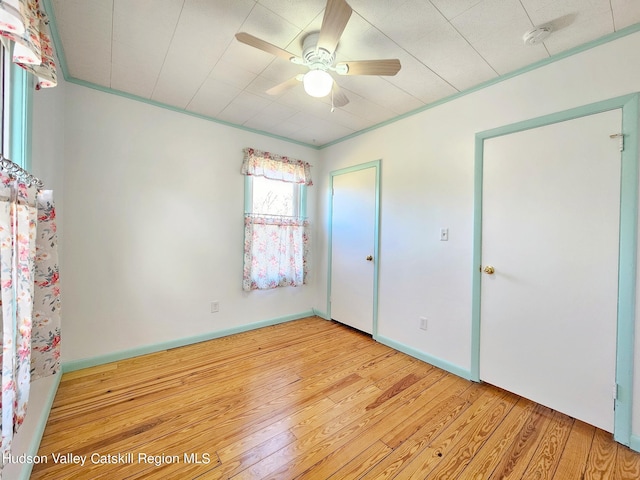 unfurnished bedroom featuring ceiling fan, light hardwood / wood-style flooring, and crown molding