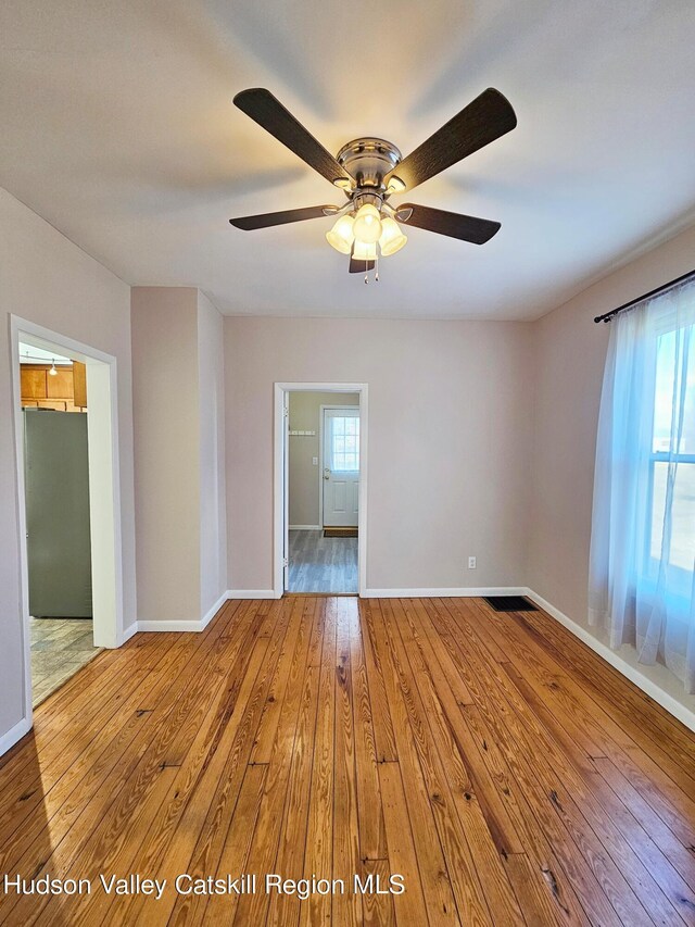 spare room with hardwood / wood-style flooring, ceiling fan, and a wealth of natural light