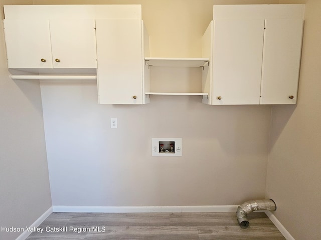 laundry area featuring hookup for a washing machine, hardwood / wood-style floors, and cabinets