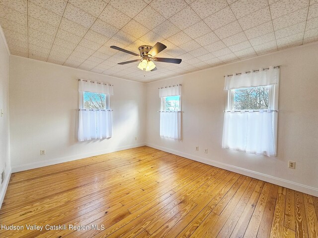 spare room with ceiling fan, wood-type flooring, and crown molding