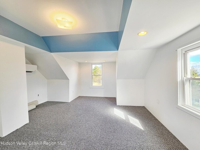 bonus room featuring carpet floors, an AC wall unit, and vaulted ceiling