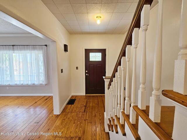 entryway featuring plenty of natural light, ornamental molding, and hardwood / wood-style flooring