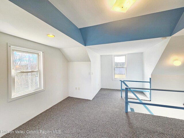 bonus room with carpet floors, a healthy amount of sunlight, and vaulted ceiling