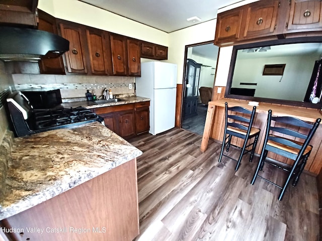 14 Center Rd, High Falls, NY 12440 - kitchen featuring freestanding refrigerator, extractor fan, gas range oven, dark wood-type flooring, and backsplash