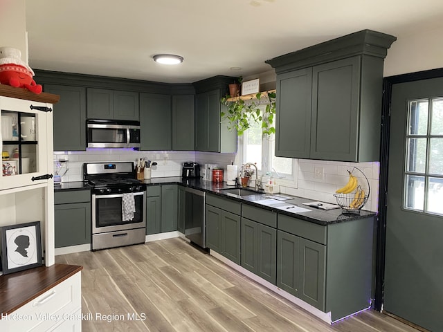kitchen featuring plenty of natural light, a sink, appliances with stainless steel finishes, and backsplash