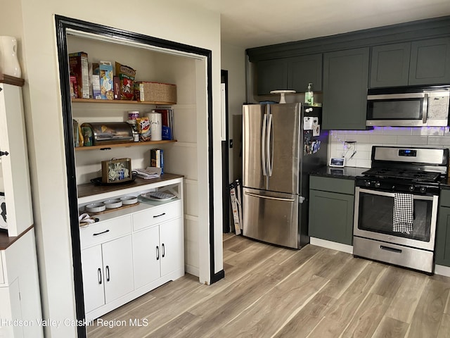 kitchen featuring appliances with stainless steel finishes, backsplash, and light wood-style flooring