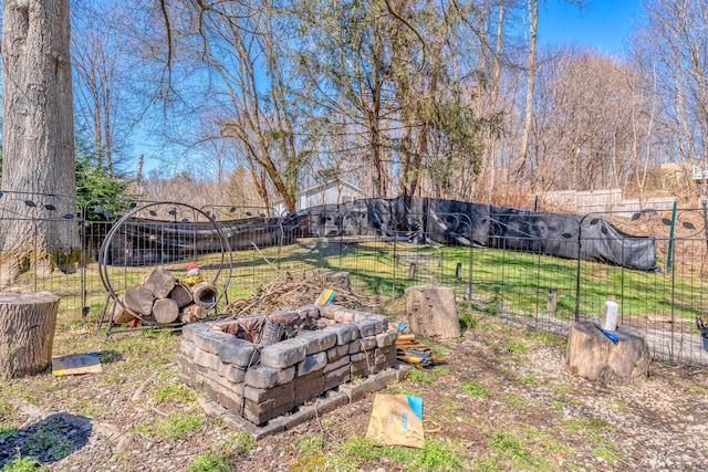view of yard with fence and a fire pit