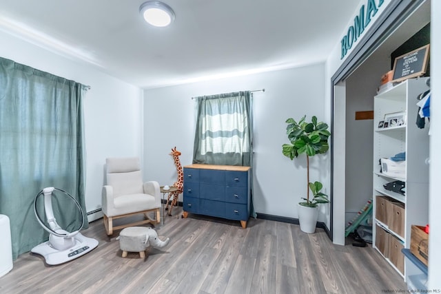 sitting room with a baseboard radiator and wood finished floors