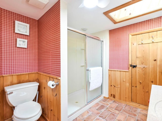 161 Beaver Hill Rd, Gilboa, NY 12076 - full bath featuring a shower stall, toilet, stone finish flooring, ceiling fan, and wood walls