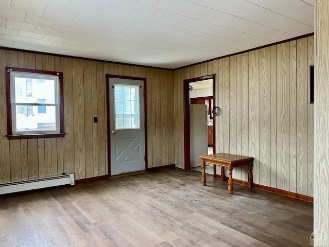 doorway featuring wood finished floors, a baseboard radiator, and wooden walls