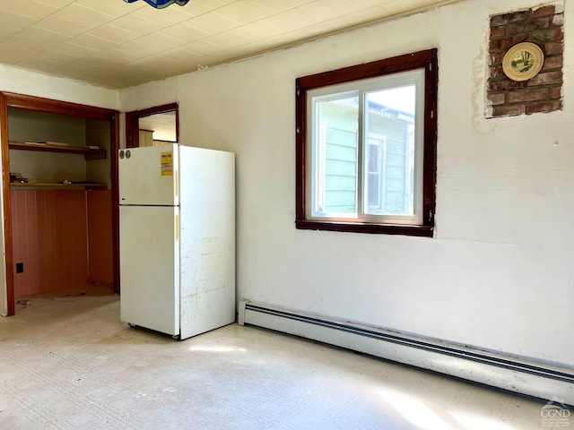 unfurnished dining area with baseboard heating and light floors