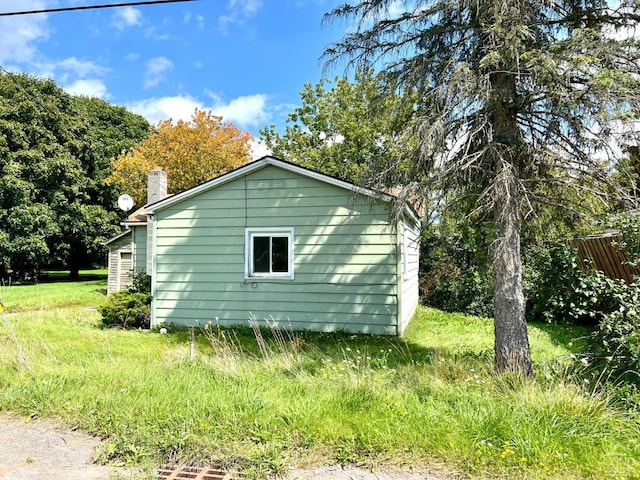 view of property exterior with a chimney and fence