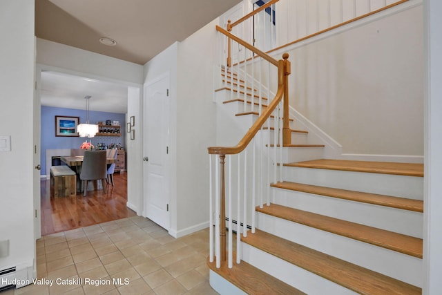 14 Glenerie Ln, Saugerties, NY 12477 - staircase featuring a baseboard heating unit, tile patterned flooring, and a chandelier