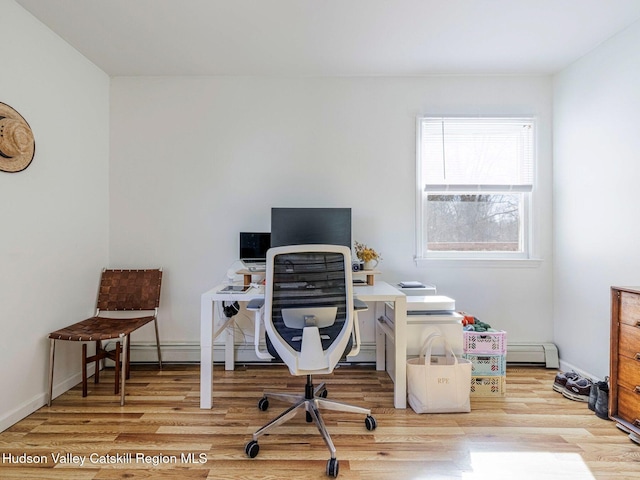 office space featuring light wood finished floors, baseboard heating, and baseboards