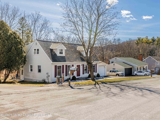 cape cod house with a garage and roof with shingles