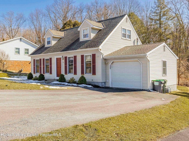 cape cod-style house with a garage, driveway, and a shingled roof