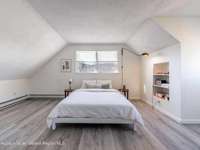 bedroom featuring baseboards, a baseboard heating unit, vaulted ceiling, and wood finished floors