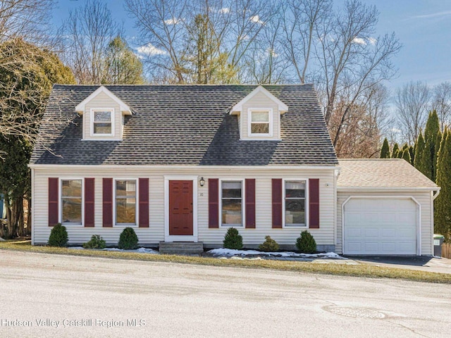 cape cod-style house featuring an attached garage, entry steps, and roof with shingles