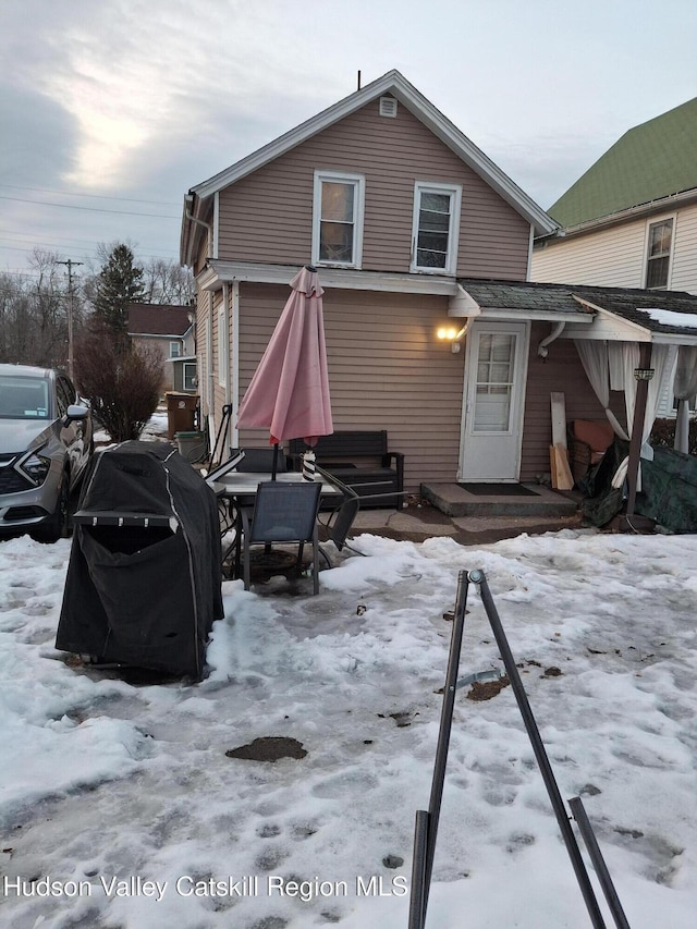 view of snow covered back of property