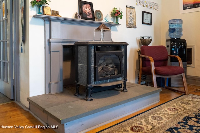 interior details featuring a wood stove and hardwood / wood-style floors