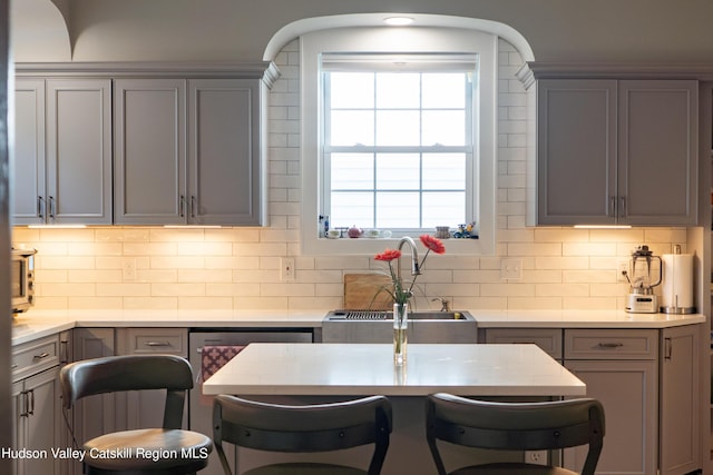 kitchen featuring decorative backsplash, gray cabinets, and sink