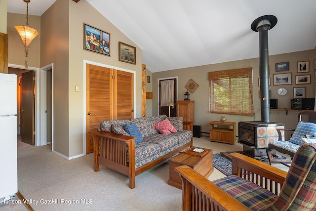 101 Hunter Ln, Hunter, NY 12442 - living area with a wood stove, light carpet, high vaulted ceiling, baseboard heating, and baseboards