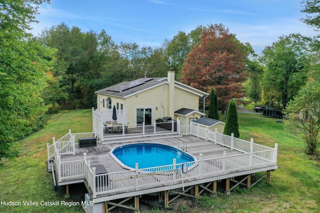 view of pool with a deck and a yard