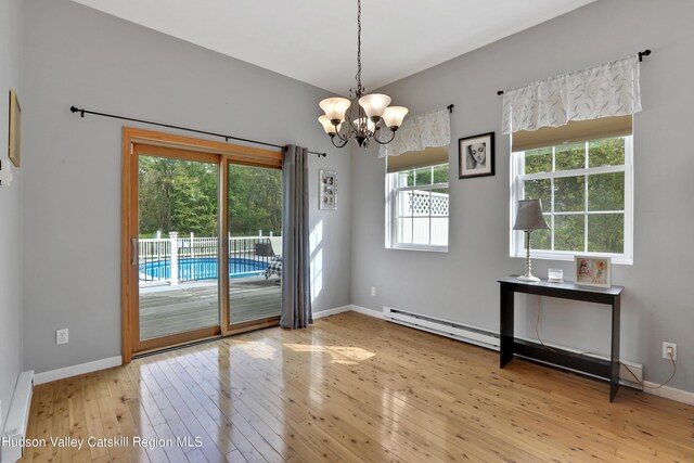 entryway with light hardwood / wood-style floors, an inviting chandelier, and a baseboard radiator