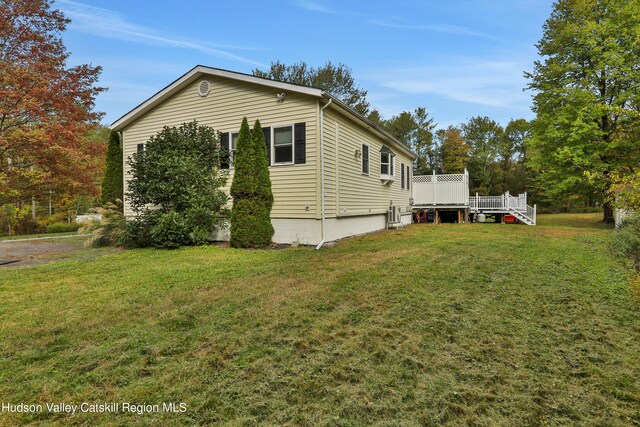 view of home's exterior featuring a wooden deck and a yard