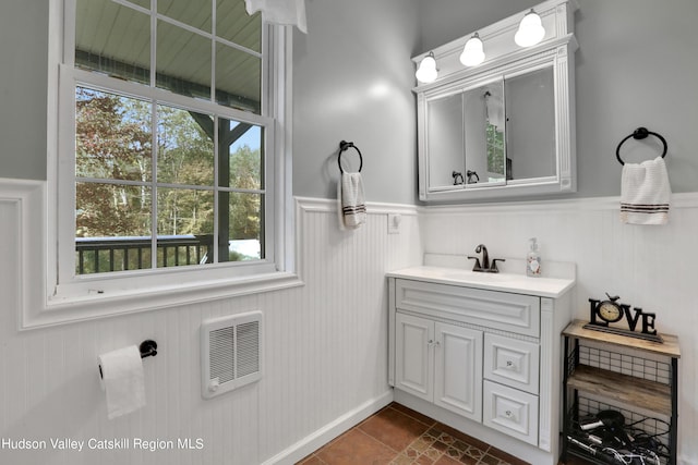 bathroom featuring heating unit and vanity