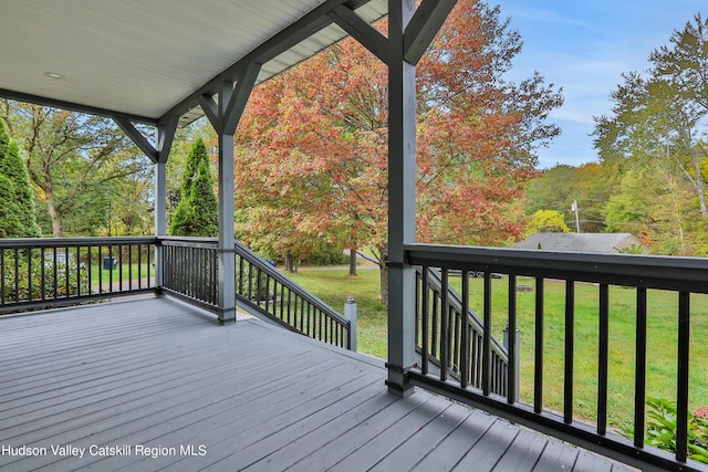 wooden deck with a lawn and a porch