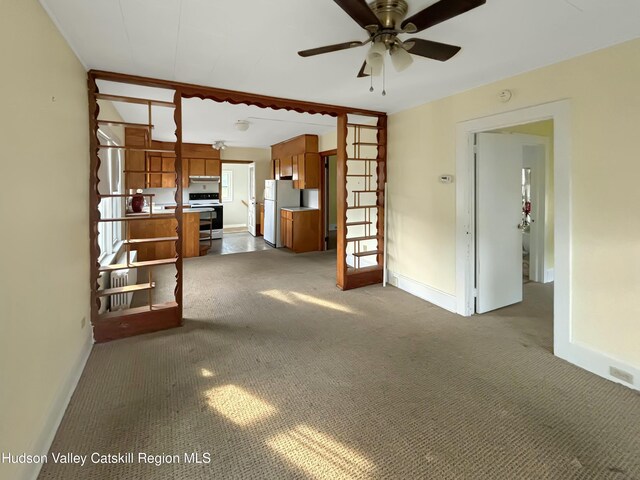 unfurnished living room with ceiling fan and dark colored carpet