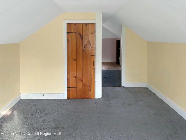 additional living space with vaulted ceiling and carpet