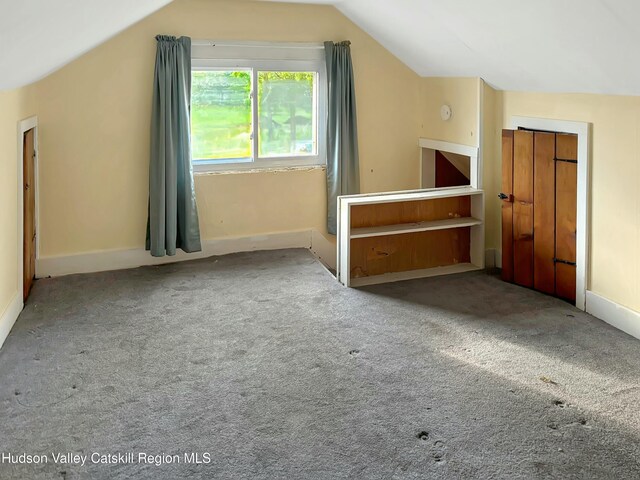 bonus room with light carpet and lofted ceiling