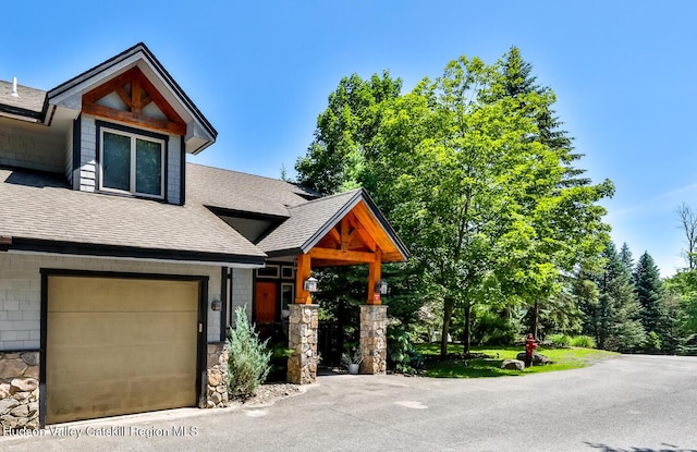 2 Watch Hill Ln Unit 2, Windham, NY 12496 - view of front of home featuring a shingled roof, a garage, and stone siding