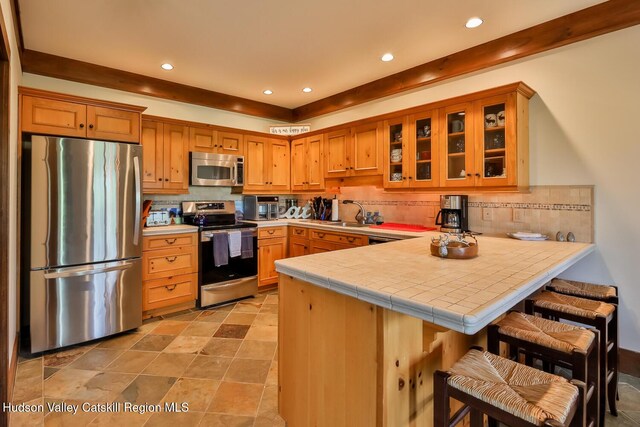 2 Watch Hill Ln Unit 2, Windham, NY 12496 - kitchen with appliances with stainless steel finishes, a peninsula, decorative backsplash, recessed lighting, and glass insert cabinets