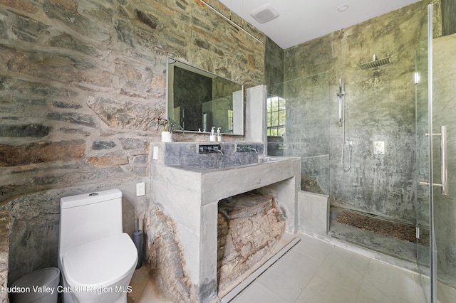 bathroom featuring tiled shower, tile patterned flooring, and toilet