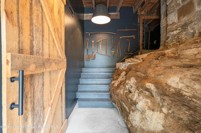 stairs with concrete flooring and wood ceiling