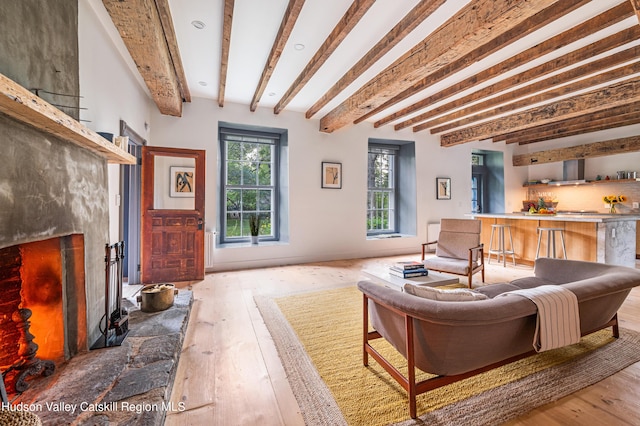 living room with light hardwood / wood-style flooring and beamed ceiling