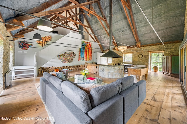 unfurnished living room featuring high vaulted ceiling and wood-type flooring